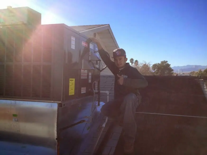 HVAC technician performing Heat Pump Repair on a rooftop unit in Midvale